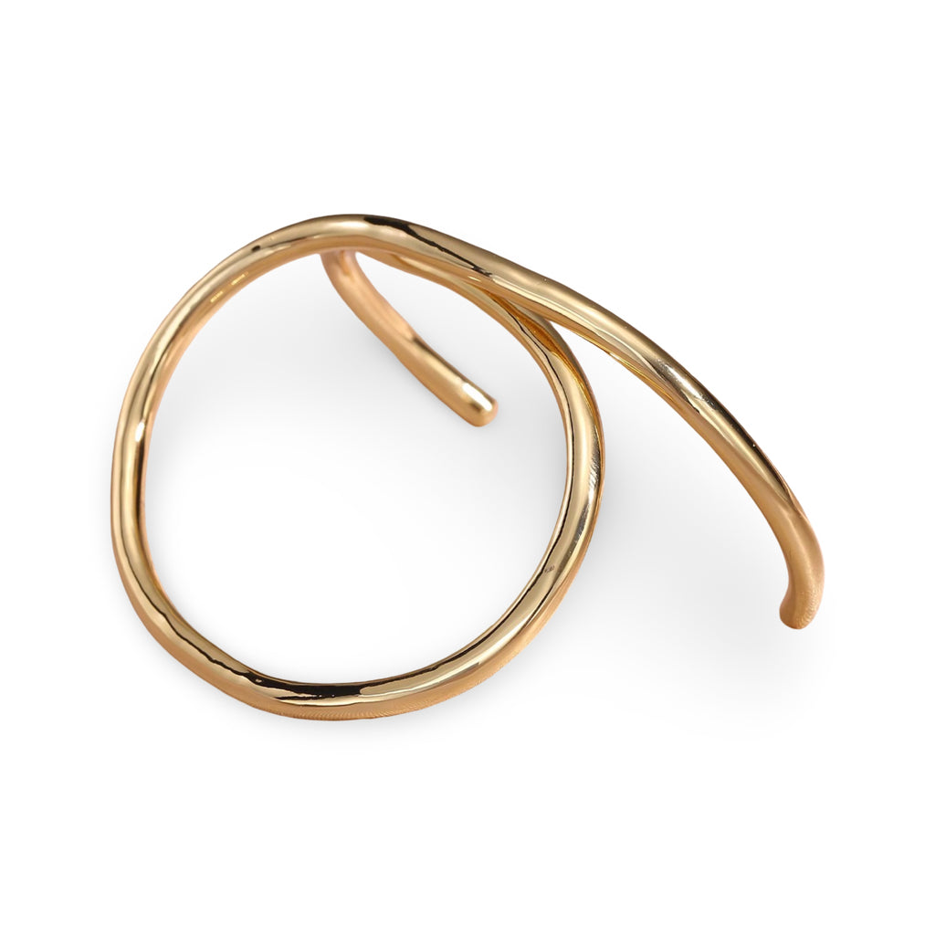A polished gold open cuff bracelet with a smooth, flowing organic loop design